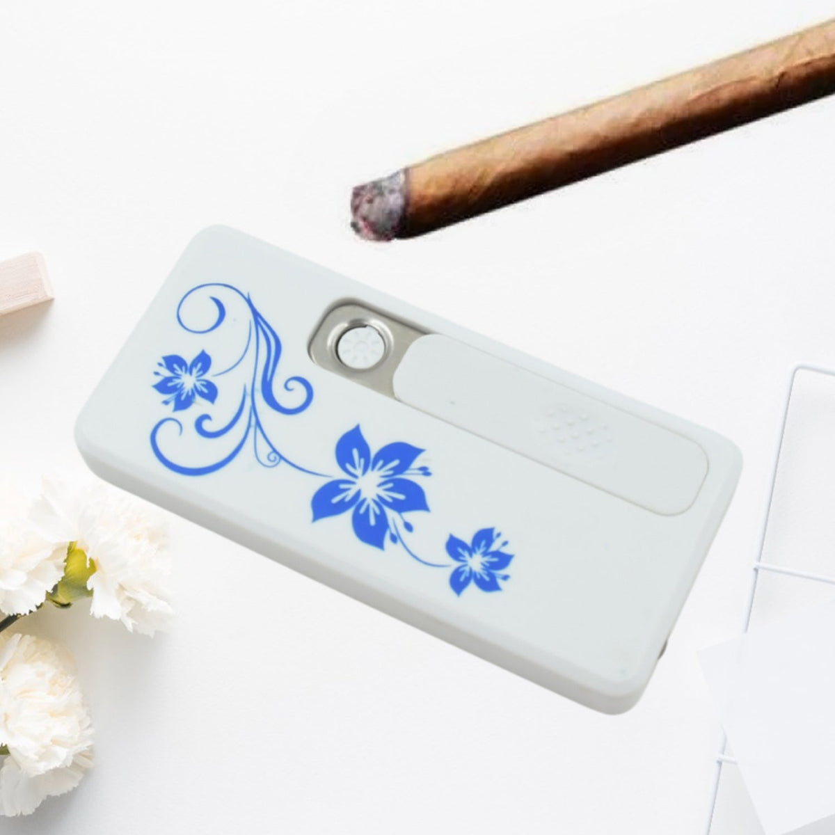 Pocket-sized white USB rechargeable plasma lighter with blue floral design held comfortably in hand.