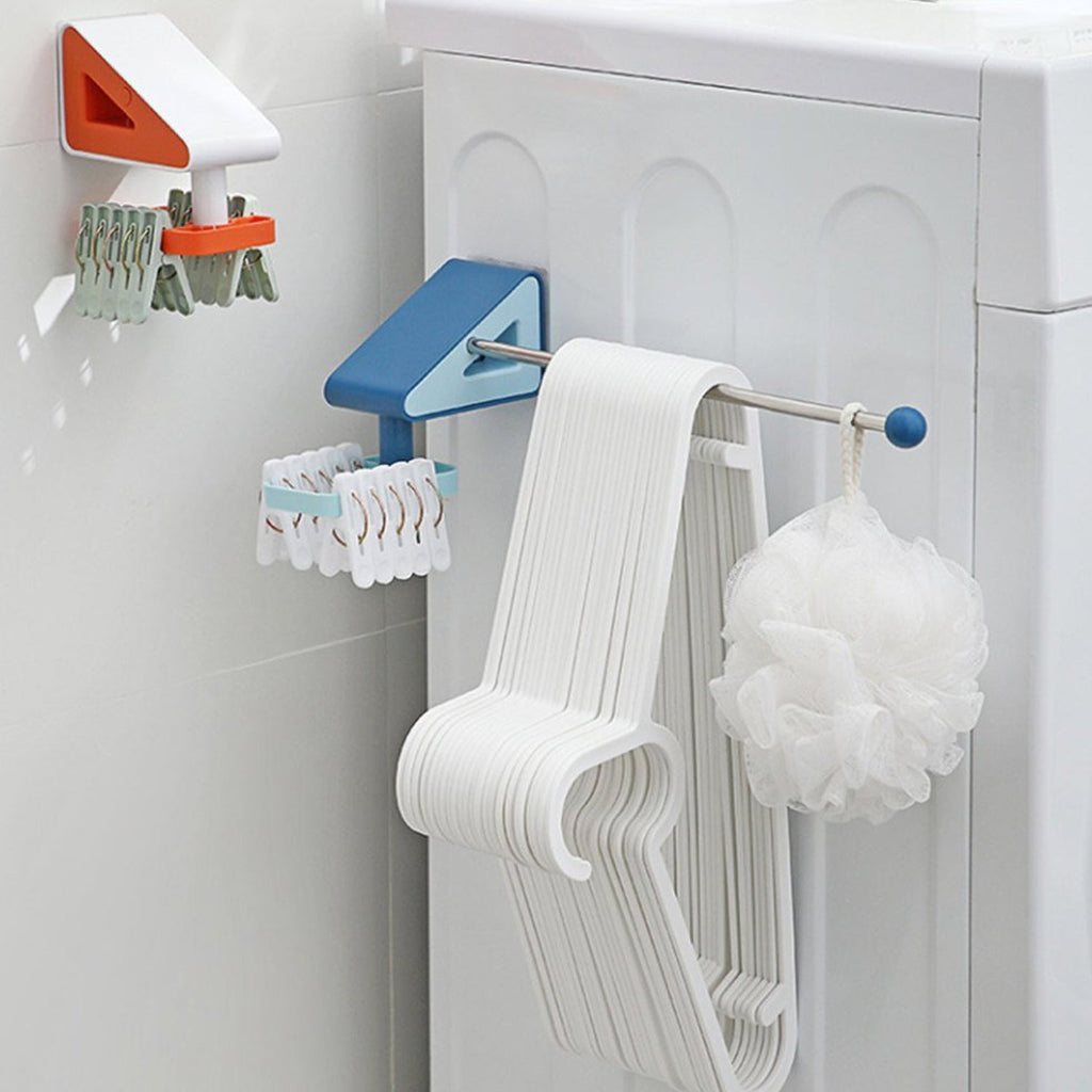 Two wall-mounted drying racks, one blue and one orange, holding hangers, clips, and a white loofah in a laundry room.