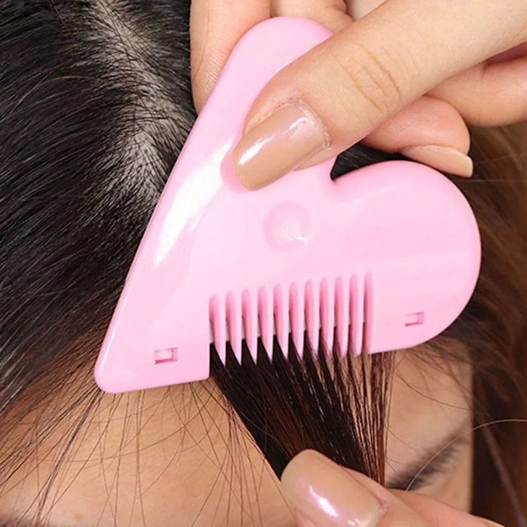 A hand uses a pink heart-shaped razor comb to thin a section of dark hair.