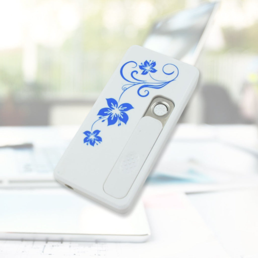 White USB lighter with blue floral pattern on a white laptop keyboard with a blurred background.