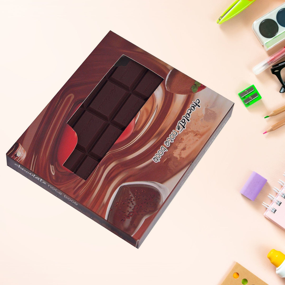 A chocolate bar shaped notebook in its packaging, with a clear window showing the product.