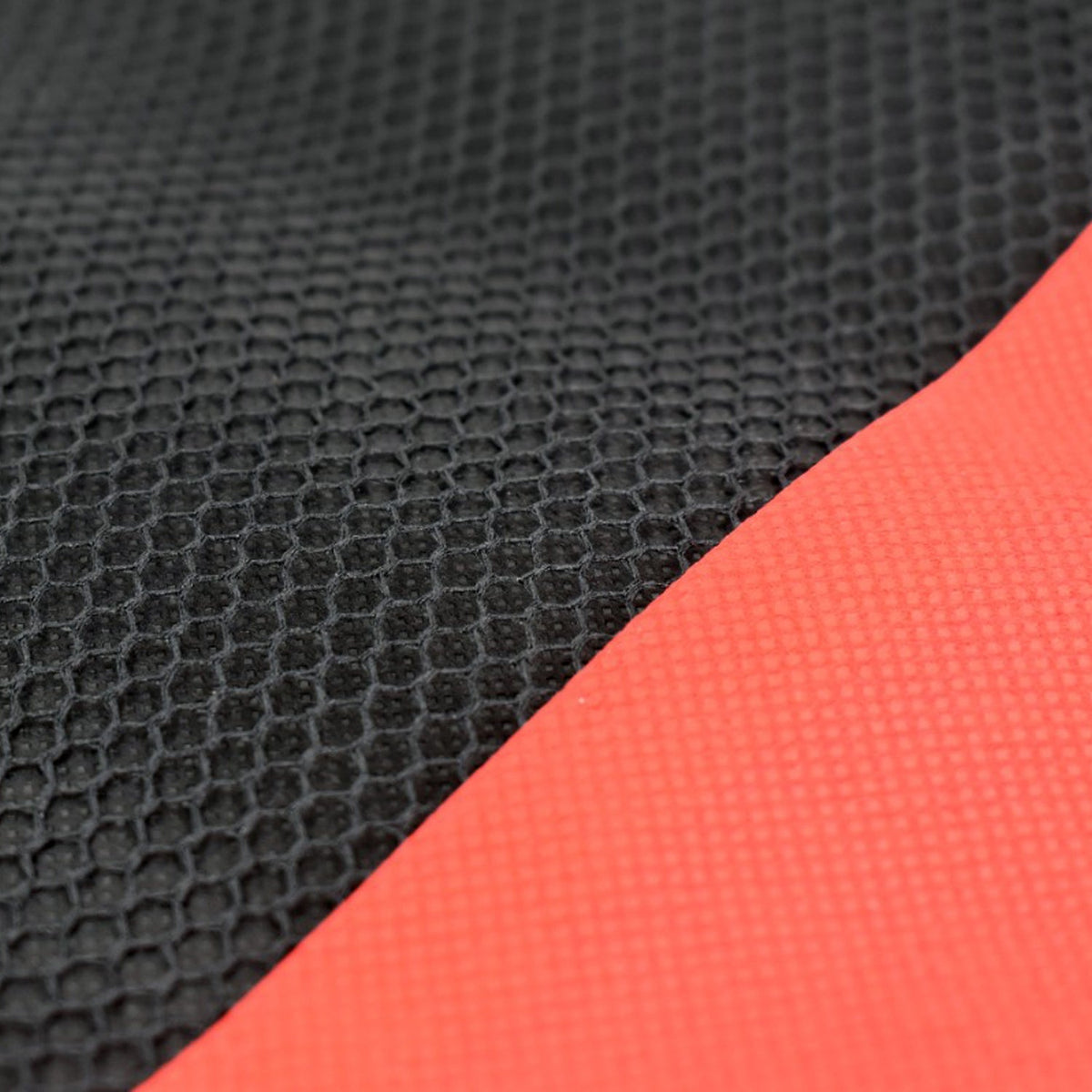 Close-up of the black mesh and red fabric textures of the laptop sleeve.