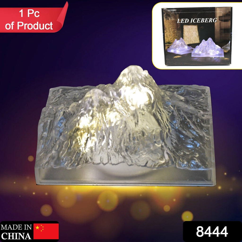 A single clear LED iceberg light with warm glow is displayed on a purple background, with packaging shown top right.