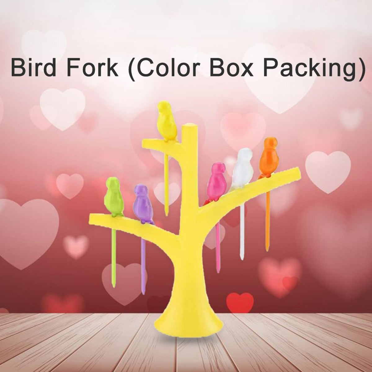 A yellow tree holder with colorful bird fruit forks on a wooden surface with a pink heart-patterned background.
