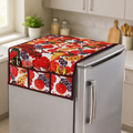 A vibrant fruit-patterned refrigerator top cover with side pockets, holding kitchen tools, on a silver fridge in a kitchen.