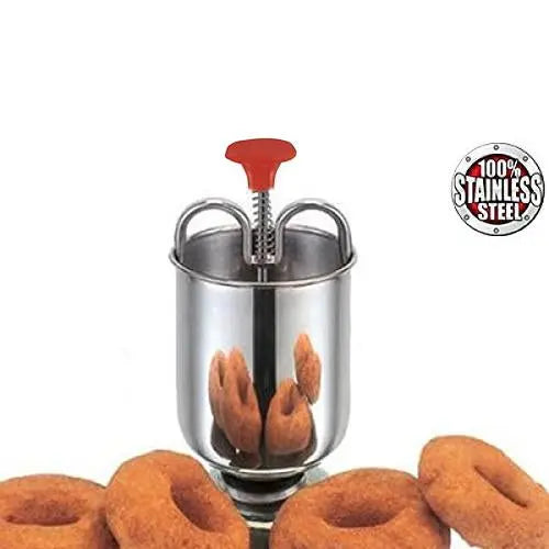 A stainless steel medu vada maker with a red handle, surrounded by several vadas, with a "100% Stainless Steel" label.