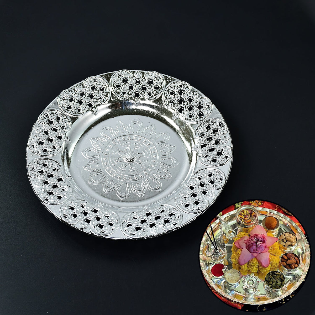 A silver-colored plastic pooja thali with a decorative embossed center and filigree border, with a small inset showing a