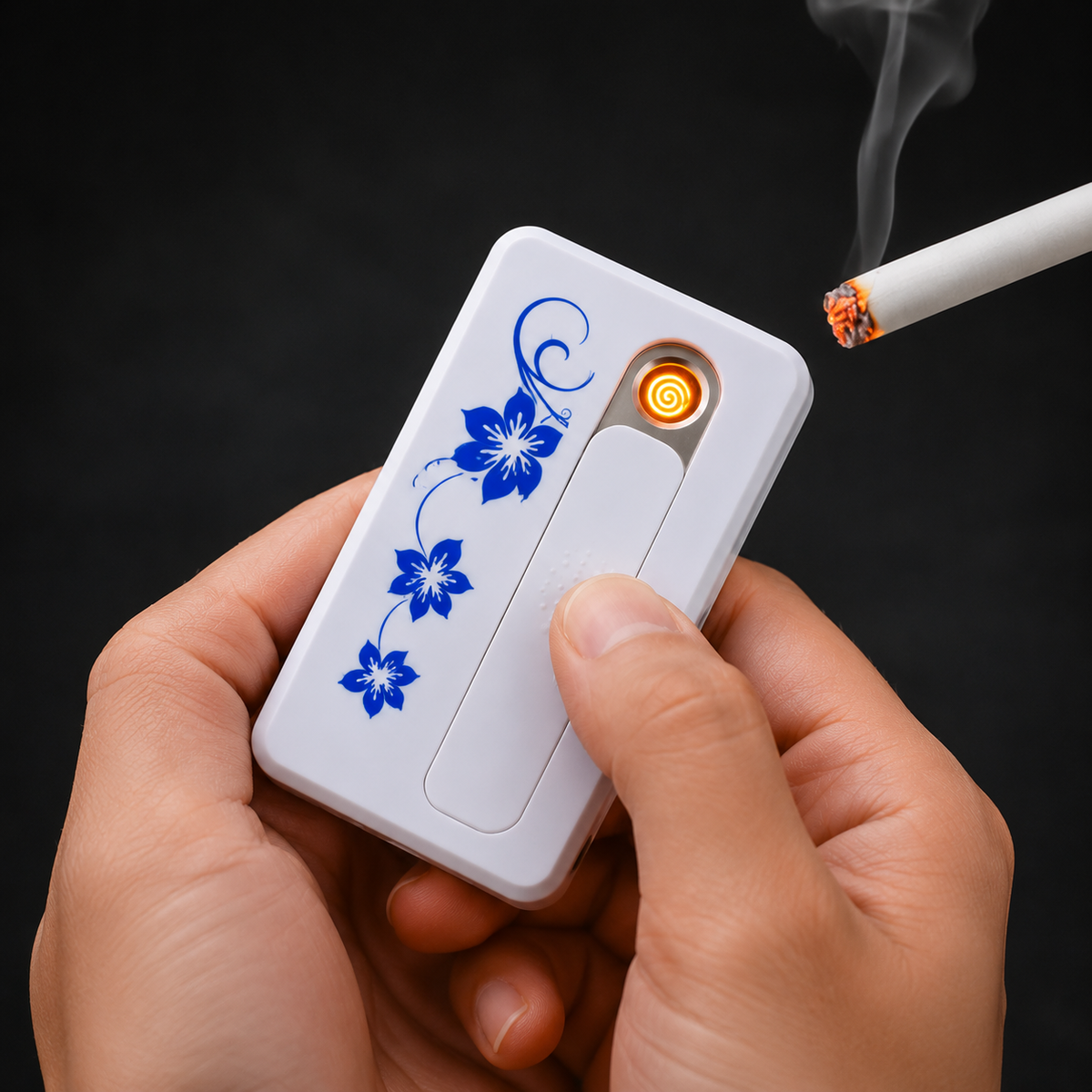Hands hold a white USB lighter with blue floral pattern, igniting a cigarette with a glowing orange coil.