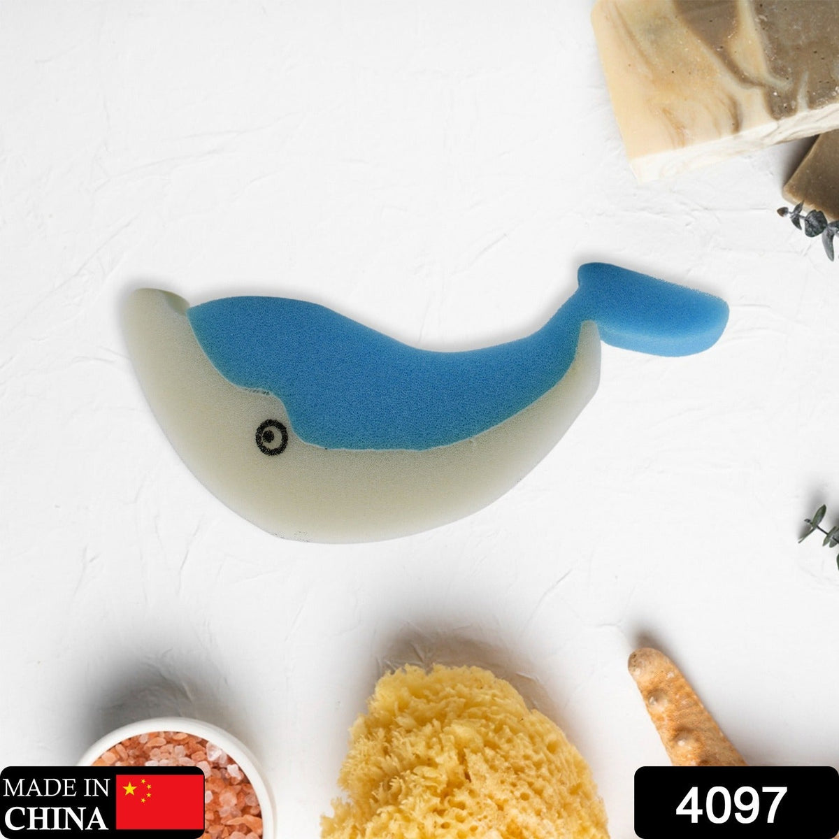 The blue and white dolphin sponge is centered on a white surface with bath items, including a "Made in China" label.