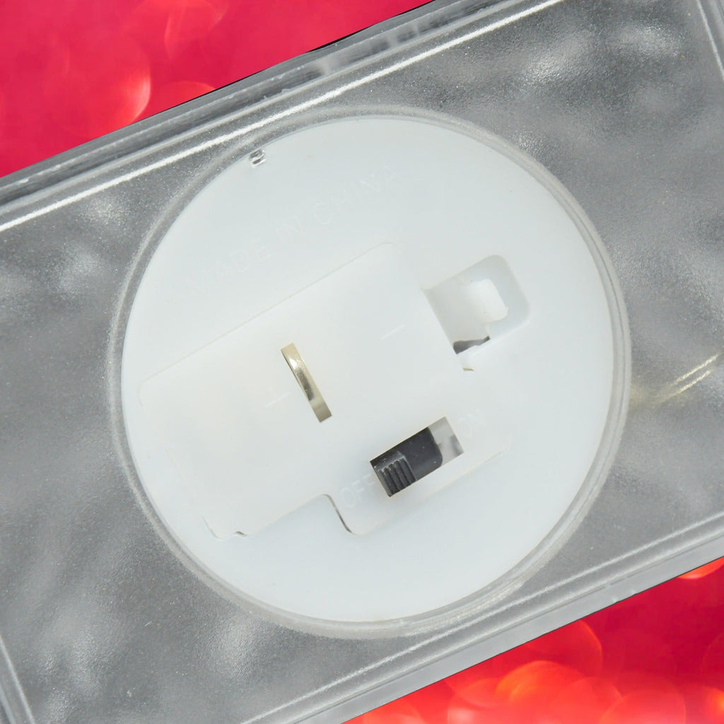 A close-up of the bottom of the clear LED iceberg light reveals a white battery compartment with an on/off switch.